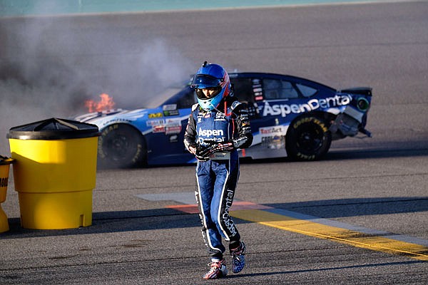 Danica Patrick walks away from her car as it catches fire after hitting the wall Sunday during the NASCAR Cup Series race at Homestead-Miami Speedway in Homestead, Fla.