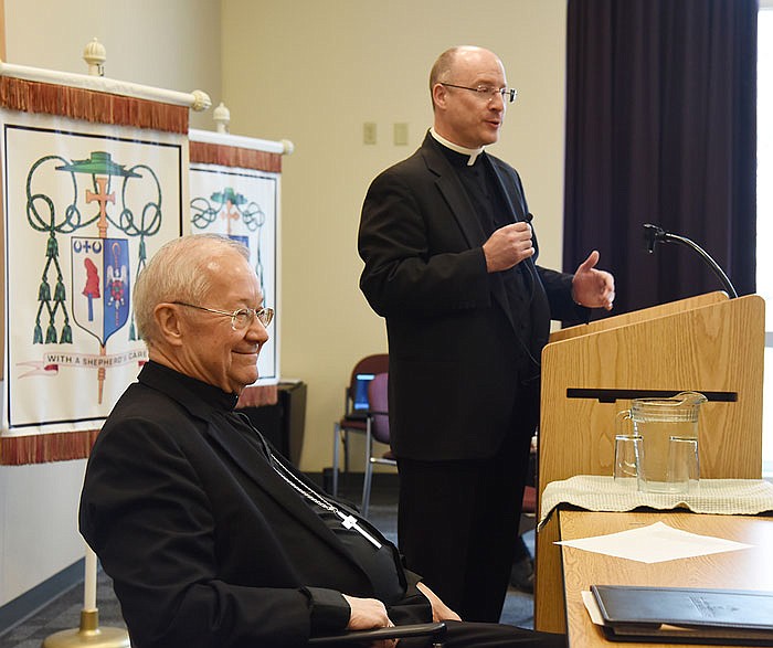 Bishop John Gaydos, seated at left, smiles after comments from the Rev. Shawn McKnight, standing, who was introduced Tuesday as the bishop-elect for the Jefferson City Diocese. Gaydos is stepping down for health reasons.