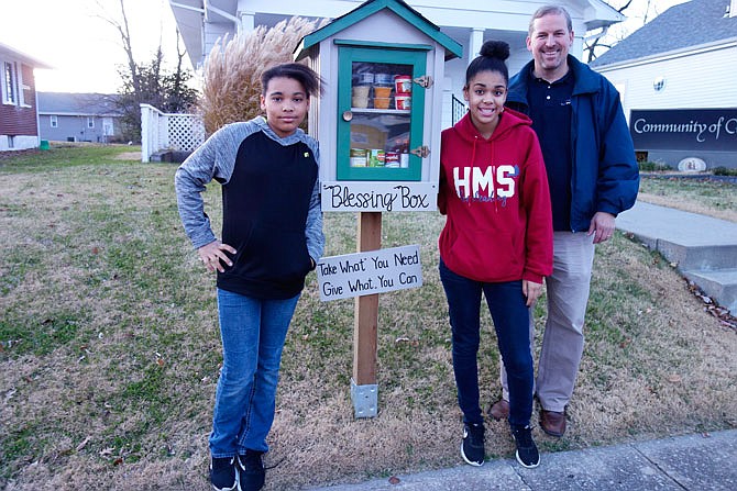 Proud of their blessing box are, from left, Kierra Thomas, 12; Akista McKenzie, 15, and Craig Snethen. They and Akista's sister, BriAna McKenzie, 13, worked on this church project.
