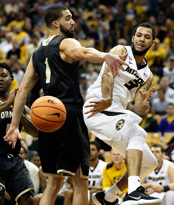 Kassius Robertson of Missouri passes around Emporia State's Stephaun Limuel during the second half of Monday night's 67-62 win by the Tigers at Mizzou Arena.