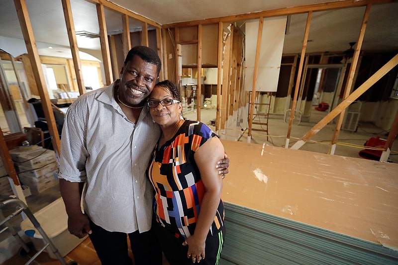 In this Nov. 17, 2017 photo, George and Arva Dorsey pose inside their hurricane-damaged home in Houston. The Dorsey's home was damaged by floodwaters from Hurricane Harvey earlier this year. They usually host a large Thanksgiving dinner for family but are making other arrangements this year as they continue to recover from the storm damage. 