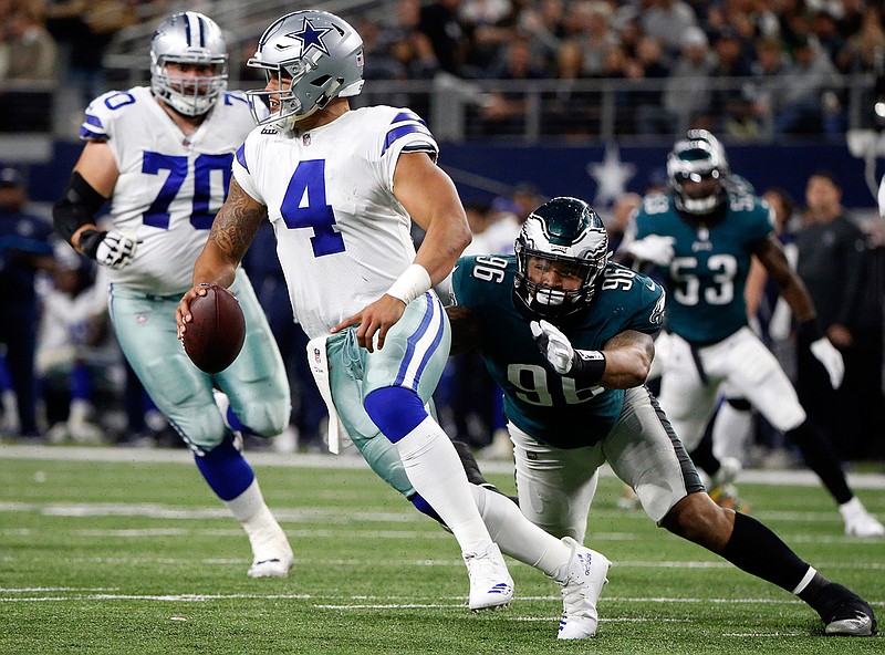 In this Sunday, Nov. 19, 2017, file photo, Dallas Cowboys quarterback Dak Prescott (4) is sacked by Philadelphia Eagles defensive end Derek Barnett (96) in the first half of an NFL football game in Arlington, Texas. The defending NFC East champs are already all but eliminated in the division race, with a tough road to a wild-card spot as well.