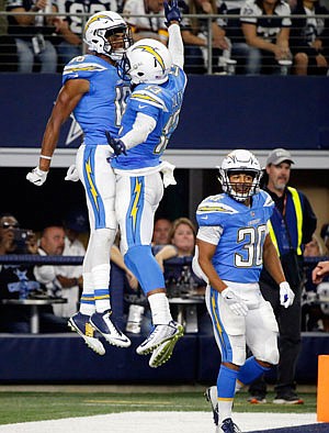 Chargers wide receivers Tyrell Williams (left), Keenan Allen (13) and Austin Ekeler (30) celebrate a touchdown reception by Williams during Thursday's game against the Cowboys in Arlington, Texas.