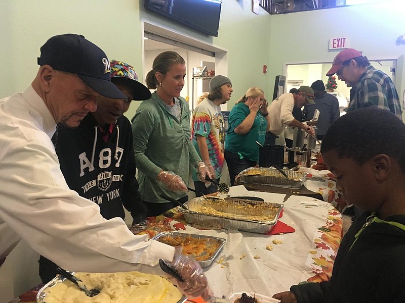  Volunteers serve a Thanksgiving lunch to anyone needing a meal Thursday at the Randy Sams' Outreach Shelter. More than 300 meals were served at the annual event.
