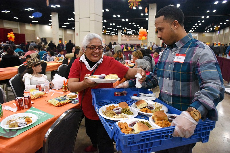Elizabeth Luna receives a plate of food during the 38th annual Raul Jimenez Thanksgiving Dinner at the Henry B. Gonzalez Convention Center in San Antonio on Thursday, Nov. 23, 2017. The event is named after a restauranteur and businessman who started the event in 1979. 