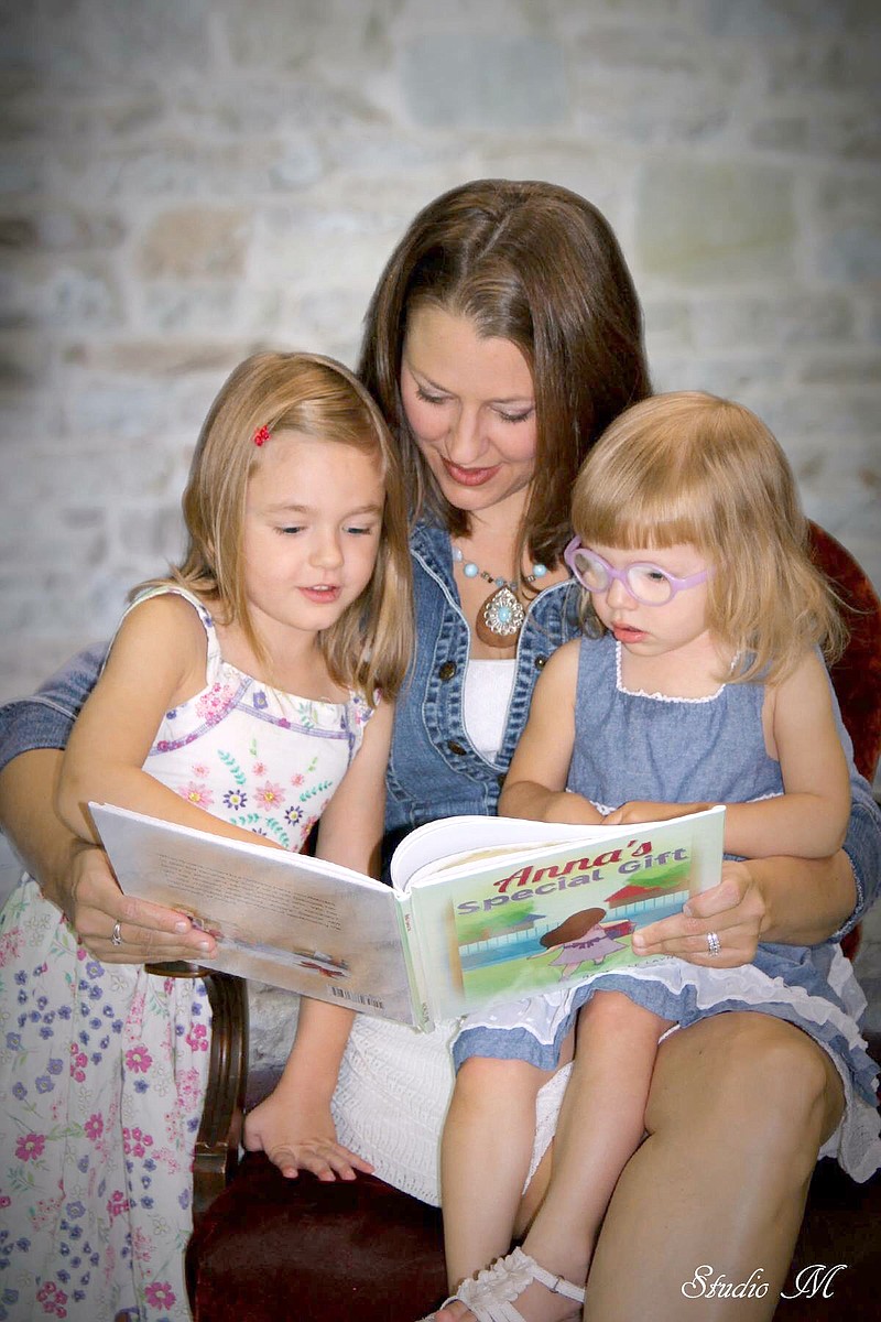 Blair Oaks teacher Rachel Schulte reads her children's book, "Anna's Special Gift," to her daughters, Kaylee and Cassandra. 