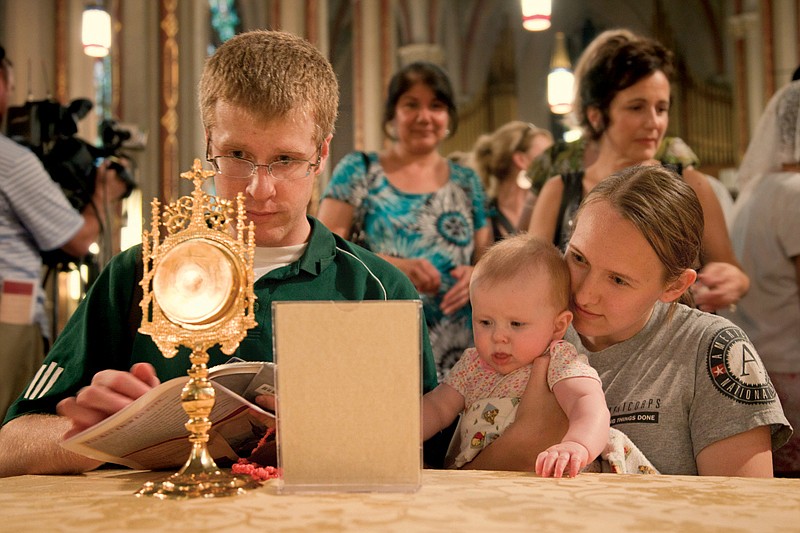  Bryan and Arlene Fair examine a fragment from the crown of thorns at St. Francis de Sales Oratory in South St. Louis.  More than 150 relics were on display throughout the church. Father Carlos Martins of Companions of the Cross gave a presentation in the parish hall before the viewing.  The relic in the glass case on the right is said to be the largest existing part of the True Cross.