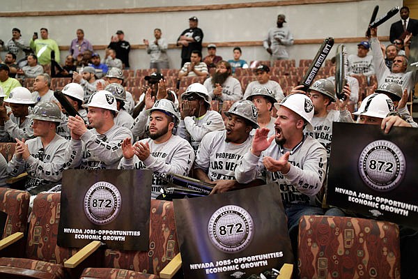 This May 18 file photo shows laborers union members cheering during a meeting of the Las Vegas Stadium Authority board in Las Vegas. A new stadium is being built in Las Vegas as the Raiders prepare to move from Oakland, Calif., to a city where sports betting is legal.