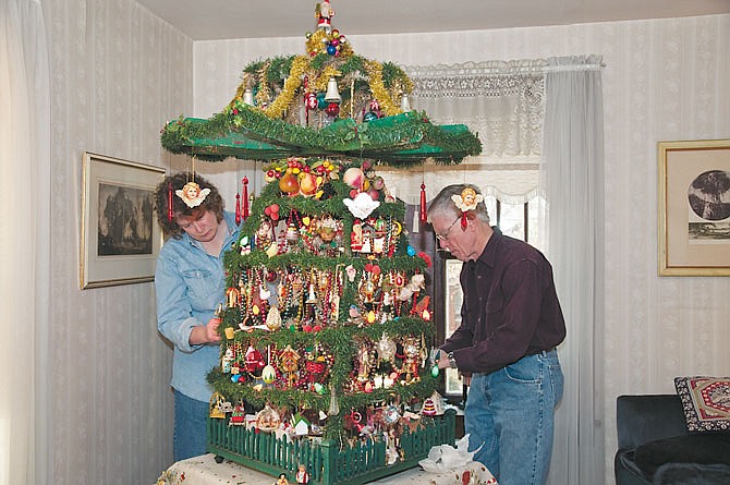 Julie and Walter Schroeder decorate their family's 126-year-old Weihnachtspyramide, or Christmas pyramid, a traditional artificial fir tree built by Walter Schroeder's grandfather after immigrating from Germany.