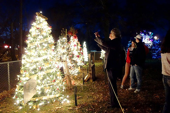 Residents admire trees Friday night in the Field of Joy in Veterans Park. Families, nonprofits and businesses sponsored more than 40 trees, with funds raised going to support the Salvation Army of Callaway County.