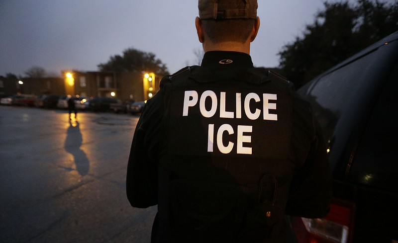 FILE - In this March 6, 2015, file photo, U.S. Immigration and Customs Enforcement agents enter an apartment complex looking for a specific undocumented immigrant convicted of a felony during an early morning operation in Dallas. The federal government provided Tuesday, Dec. 5, 2017, the most complete statistical snapshot of immigration enforcement under President Donald Trump, showing Border Patrol arrests plunged to a 45-year low while arrests by deportation officers soared. (AP Photo/LM Otero, File)