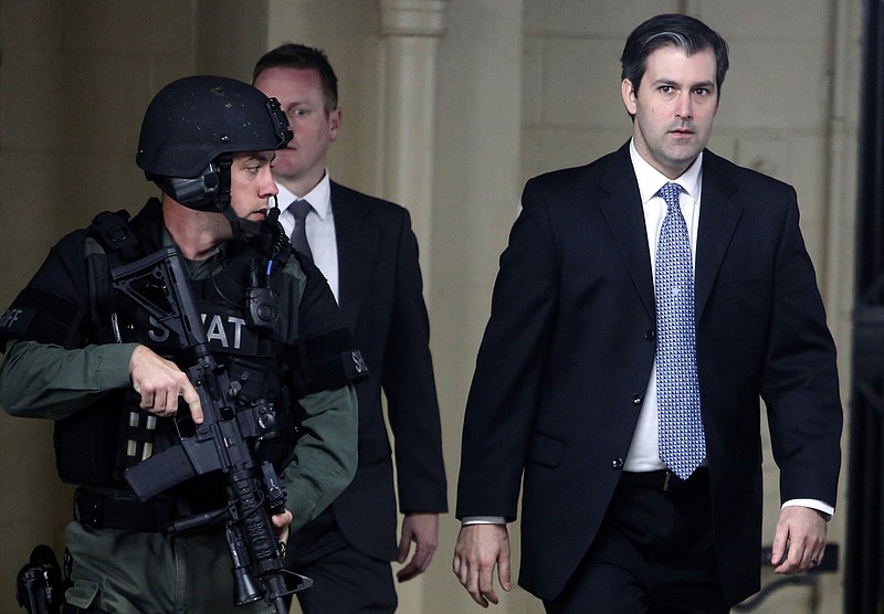 FILE - In this Monday, Dec. 5, 2016, file photo, former South Carolina police officer Michael Slager, right, walks from the Charleston County Courthouse under the protection of the Charleston County Sheriff's Department after a mistrial was declared for his trial in Charleston, S.C.  l Slager is in court Monday, Dec. 4, 2017, facing a possible life sentence for the April 2015 shooting death of Walter Scott. The foot chase and shooting were captured by a bystander on cellphone video that was seen by millions online. Slager pleaded guilty in May to violating Scott's civil rights. A state jury deadlocked last year on murder charges, which were dropped as part of his federal plea deal. (AP Photo/Mic Smith, File)