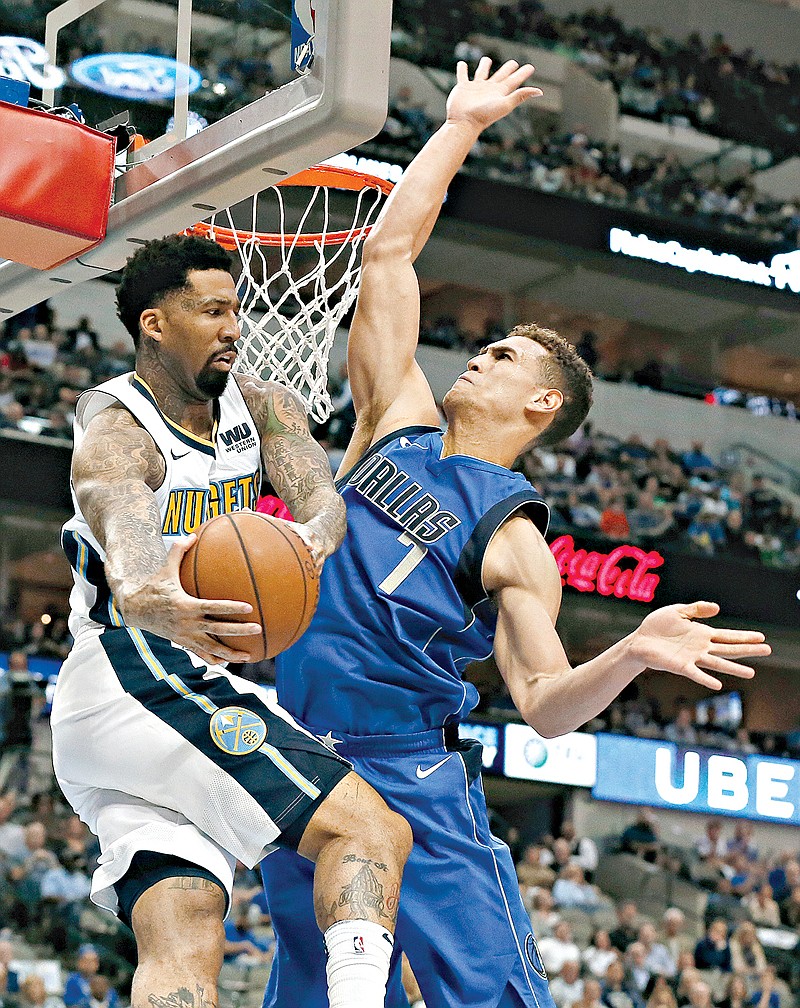 Denver Nuggets forward Wilson Chandler (21) is forced to pass the ball under pressure from Dallas Mavericks' Dwight Powell in the first half of an NBA game Monday in Dallas.