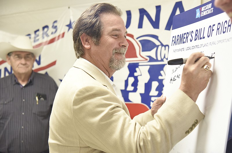 Missouri Democrats held a press conference Monday to unveil a Farmer's Bill of Rights. Former Missouri Rep. and Sen. Wes Shoemyer was among the first to sign the Farmer's Bill of Rights poster that will be carried around the state as Democrats try to build support for the proposal. Hickory County farmer, J.C. Owsley, background, was one of several to speak out on behalf of the bill.