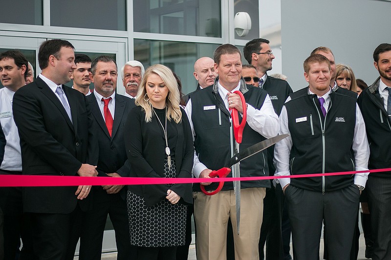 General manager Steve Robinson gets ready to cut the ribbon Tuesday at Greg Orr's Classic Chrysler Dodge Jeep Ram dealership. The previous location of the dealership was no longer big enough to hold the burgeoning business. "We needed more room for it all," said Haley Youngblood, marketing manager.
