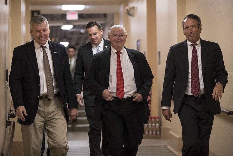 In this Dec. 5, 2017, photo, House Republicans, from left, Rep. Rob Woodall, R-Ga., Rep. Richard Hudson, R-N.C., Rep. Joe Barton, R-Texas, and Rep. Mark Sanford, R-S.C., arrive for a closed-door strategy session on Capitol Hill in Washington. Sounding a discordant note among the positive talk on the tax bill, a number of Republicans are delivering a blunt assessment, casting the bill as a boost to big corporations and the wealthy instead of the middle class. "Fundamentally if you look at the bulk of the bill, two-thirds of it, it's tied on the business side," Sanford said Tuesday as leaders in the House and Senate hailed their respective measures as an advantage for working Americans.