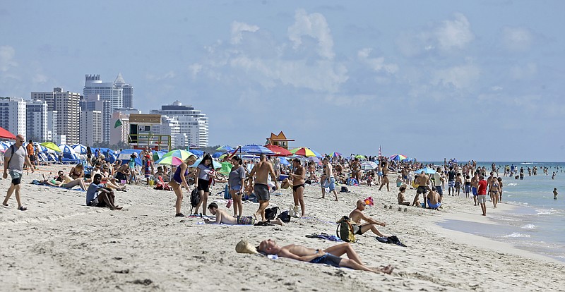 FILE - In this Aug. 2, 2017, file photo, local residents and tourists enjoy a day at the beach in the South Beach area of Miami Beach, Fla. South Beach can be a great place for parents and teens to vacation together, especially if they can go their separate ways at times for beach, pool, shopping and dining. (AP Photo/Alan Diaz, File)