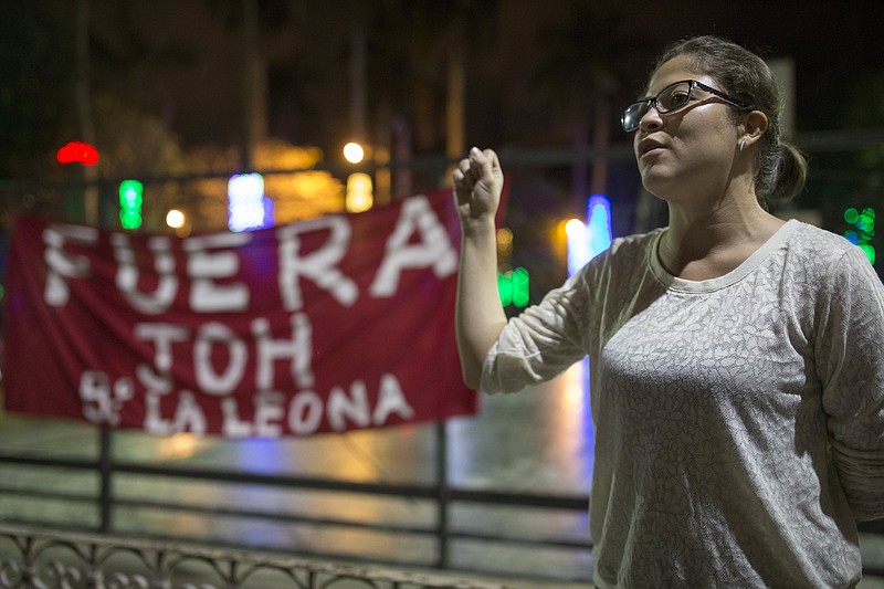 An anti-government demonstrator sings the Honduras national anthem protesting against the government imposed dawn-to-dusk curfew in Tegucigalpa, Honduras, late Tuesday, Dec. 5, 2017. Honduran President Juan Orlando Hernandez holds a narrow lead in the official results for the presidential election from the Supreme Electoral Tribunal, a count that his rival Salvador Nasralla has claimed was fraudulent and is refusing to recognized. (AP Photo/Moises Castillo)