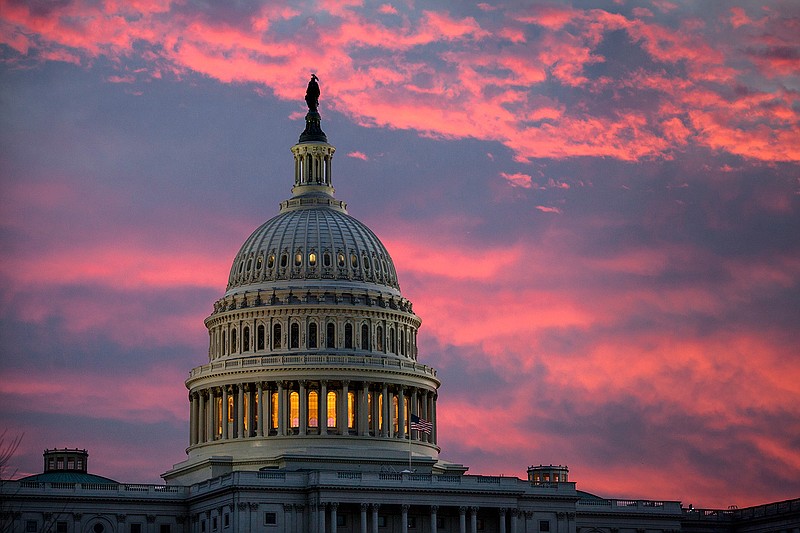 In this Thursday, Nov. 30, 2017, file photo, the sky over The Capitol is lit up at dawn as Senate Republicans work to pass their sweeping tax bill, in Washington. Congress' last major tax overhaul, three decades ago, was everything this year's version isn't. The Tax Reform Act of 1986 won bipartisan support. Its benefits flowed more to low- and middle-income taxpayers than to wealthy individuals and corporations. And it added nothing to the federal deficit. None of that can be said for tax-cut package the Senate passed after the House approved a similar version. 