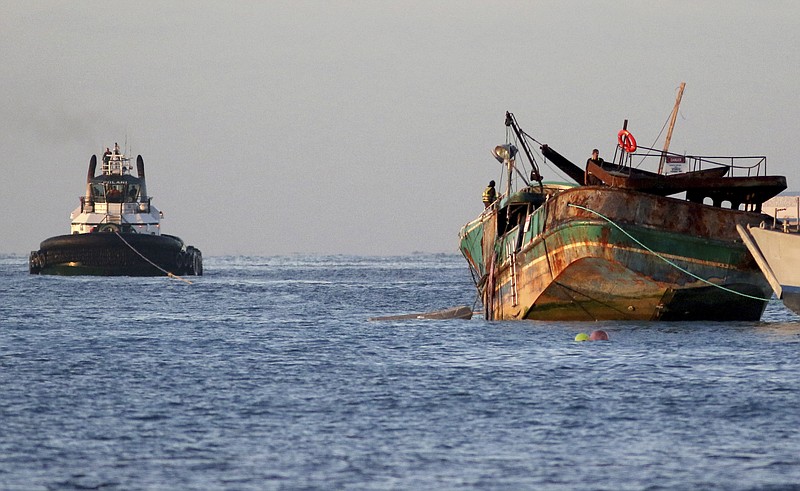 The fishing vessel Pacific Paradise is towed out to sea after being removed from a reef just off Waikiki where it ran aground nearly two months ago, Thursday, Dec. 7, 2017 in Honolulu. The commercial fishing vessel was carrying foreign workers to Hawaii when it crashed into the reef and later caught fire and leaked fuel into the ocean. It will be sunk by a team of salvage workers at an EPA-approved site about 13 miles south of Oahu. (AP Photo/Caleb Jones)