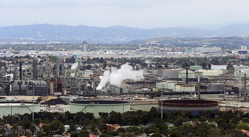 FILE - This May 25, 2017 aerial file photo shows the Standard Oil Refinery in El Segundo, Calif., with Los Angeles International Airport in the background and the El Porto neighborhood of Manhattan Beach, Calif., in the foreground. California Attorney General Xavier Becerra announced, Thursday, Dec. 7, 2017, that California is among fourteen states and the District of Columbia that are suing the Trump administration over what they say a failure to enforce smog standards. (AP Photo/Reed Saxon, File)