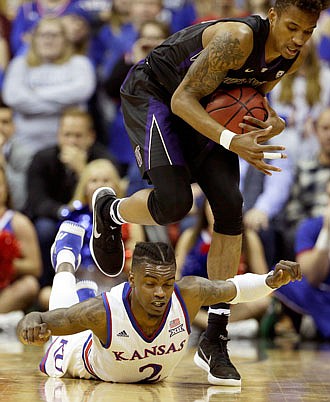 Washington's Hameir Wright beats Kansas' Lagerald Vick to a loose ball during Wednesday night's game in Kansas City.