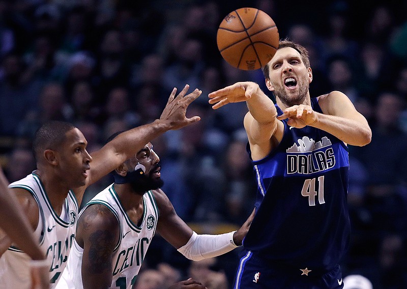 Dallas Mavericks forward Dirk Nowitzki (41) passes the ball while covered by Boston Celtics forward Al Horford, left, and guard Kyrie Irving during the first quarter of an NBA basketball game in Boston, Wednesday, Dec. 6, 2017. 