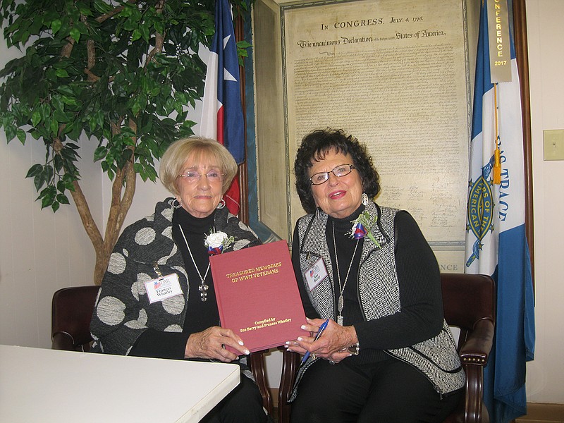 Frances Whatley, left, and Sue Berry pose with their book "Treasured Memories of World War II Veterans" during a reception honoring Pearl Harbor Day at the American Legion Hall in Atlanta, Texas.