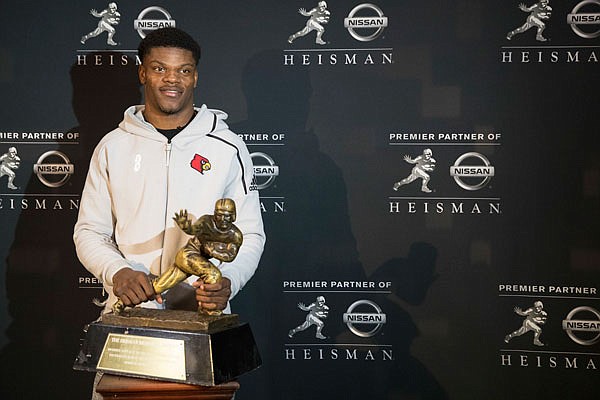 Heisman Trophy finalist and Louisville quarterback Lamar Jackson poses with the award during a media event Friday in New York.