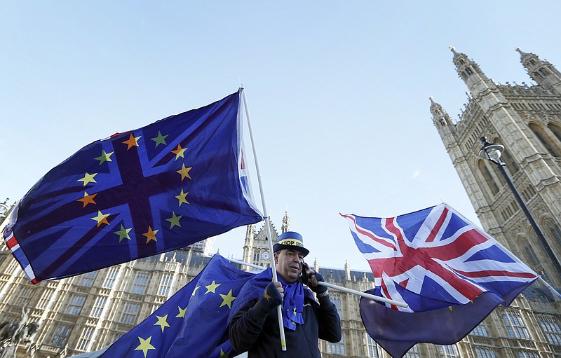 An anti Brexit demonstrator waves EU and British flags in Westminster in London, Friday, Dec. 8, 2017. British Prime Minister Theresa May, met with European Commission President Jean-Claude Juncker early Friday morning following crucial overnight talks on the issue of the Irish border. (AP Photo/Kirsty Wigglesworth)