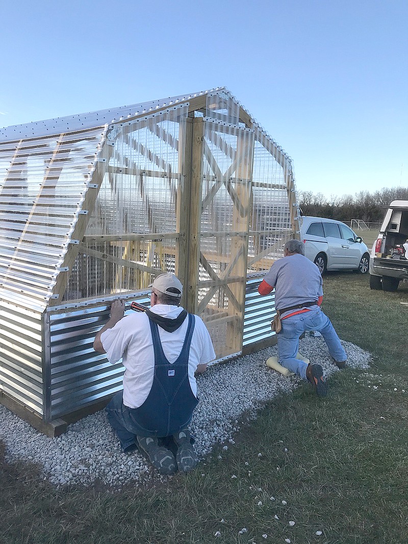 Master Gardeners Roger Elliot, at left, and Joe Holtmeyer put the finishing touches on a greenhouse Dec. 1 at Callaway Hills Elementary School.