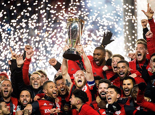 Toronto FC captain Michael Bradley hoists the trophy as the team celebrates its win Saturday against the Seattle Sounders in the MLS Cup final in Toronto.