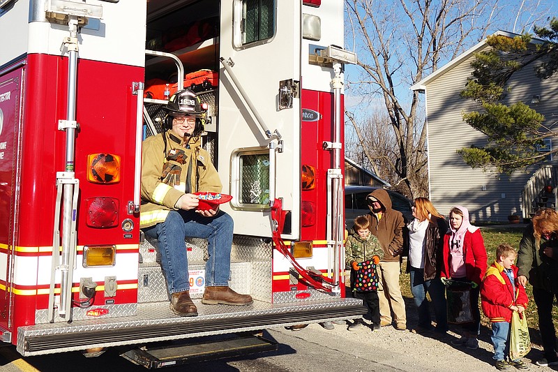 Firefighter Ben Schauffler of the Holts Summit Fire Department throws candy to children Dec. 9, 2017 during the town's annual Christmas parade.