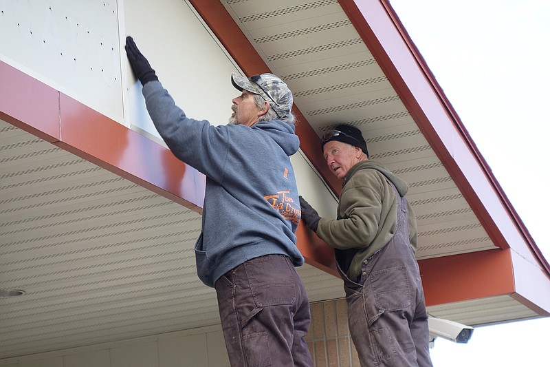 Dwayne Gray (left) and Don Hoover, of HLW Builders of Fulton, prepare the facade of the Fulton Early Childhood Center for a new sign Monday morning, Dec. 11, 2017.