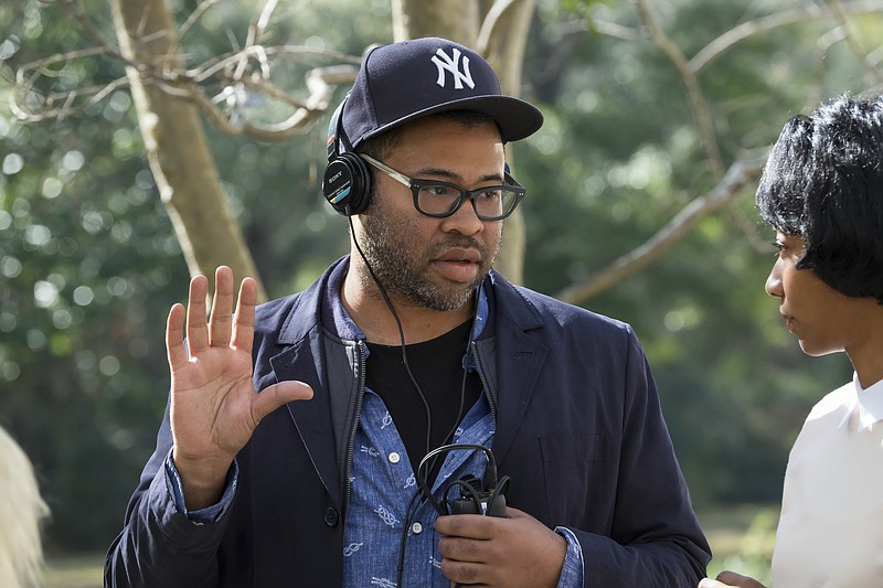 This image released by Universal Pictures shows director Jordan Peele on the set of "Get Out."  Peele failed to get a Golden Globe nomination for best director or screenplay for his critically acclaimed film on Monday, Dec. 11, 2017.  (Justin Lubin/Universal Pictures via AP)