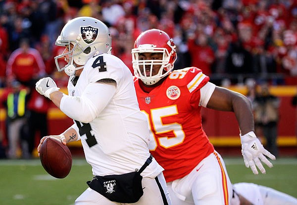 Raiders quarterback Derek Carr is pursued by Chiefs defensive lineman Chris Jones during the second half of Sunday afternoon's game at Arrowhead Stadium in Kansas City.