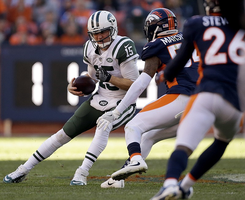 New York Jets quarterback Josh McCown (15) scrambles as Denver Broncos inside linebacker Brandon Marshall (54) prepares to make the tackle during the first half of an NFL football game Sunday in Denver. McCown was injured on the play and left the 
game. 