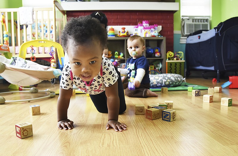 Jariah Stewart crawls across the infant room floor at Stepping Stones Preschool. Behind her is Brysen Hughes. Both are one-year-olds in the infant care program.