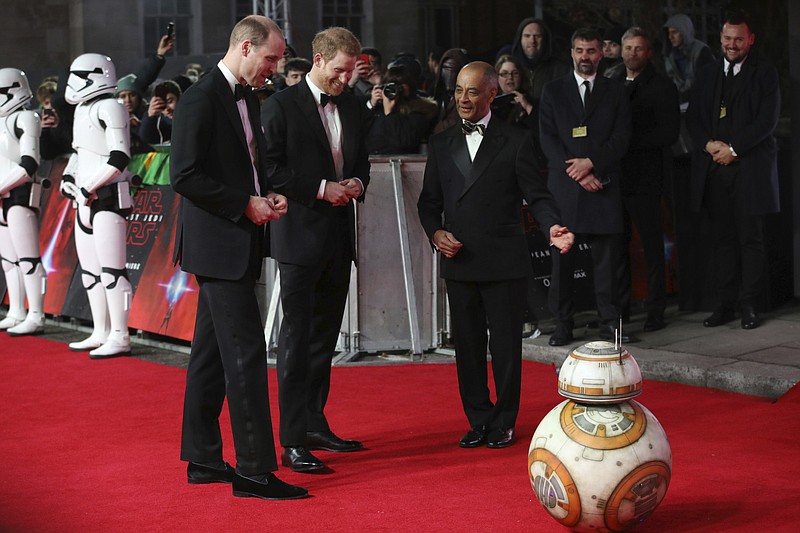 Britain's Prince William, left, and Prince Harry, centre, are introduced to a character from the film upon arrival at the premiere of the film 'Star Wars: The Last Jedi' in London, Tuesday, Dec. 12th, 2017. (Photo by Vianney Le Caer/Invision/AP)