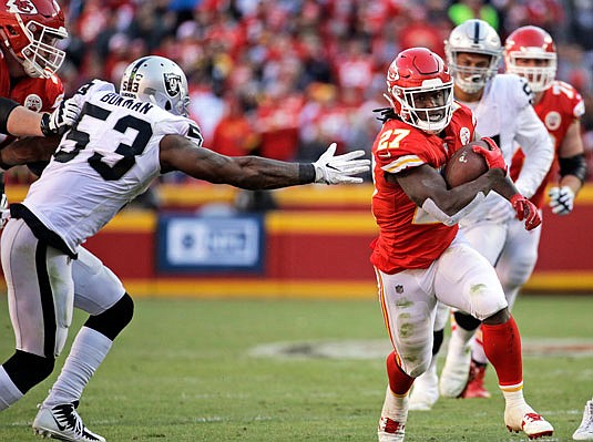 Chiefs running back Kareem Hunt evades the grasp of Raiders linebacker NaVorro Bowman during the second half of Sunday afternoon's game at Arrowhead Stadium.