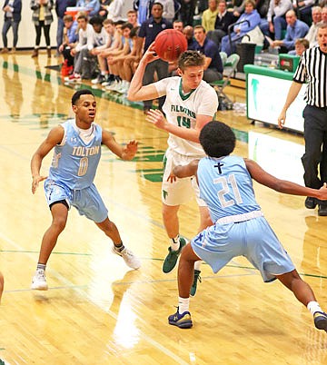 Tim Fick of Blair Oaks makes a behind-the-head pass as Father Tolton teammates Lael Haile (21) and Isaiah Johnson (0) defend during Tuesday night's game in Wardsville.