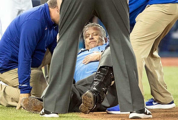 In this April 14 file photo, home plate umpire Dale Scott is looked at by medical personnel after he was hit by a foul tip during a game between the Blue Jays and Orioles in Toronto. Scott missed almost the remainder of the season and rather than risk yet another concussion, Scott has decided to retire at 58.