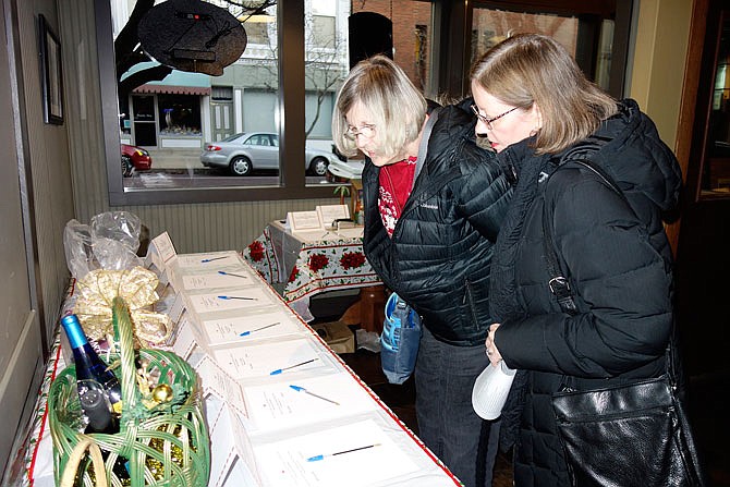 Joyce Airaghi, left, and Tina Hines shopped at Tuesday evening's silent auction at Beks restaurant. The event was raising money for Our House to help take care of homeless families.