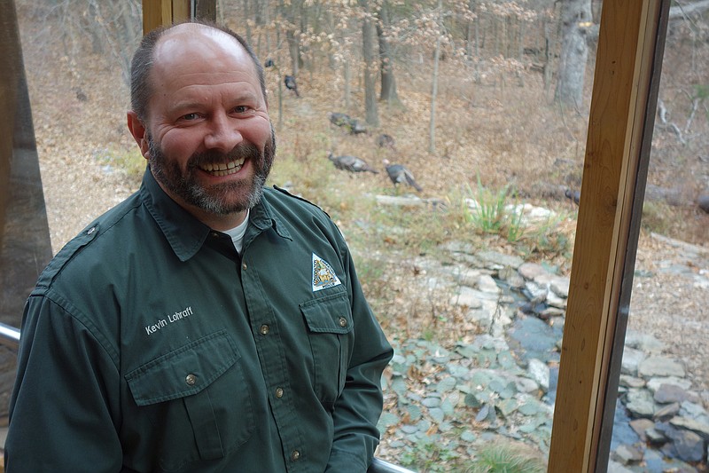 Runge Nature Center Manager Kevin Lohraff stands infront of the center's in-door nature viewing station as a rafter of turkeys pass by.