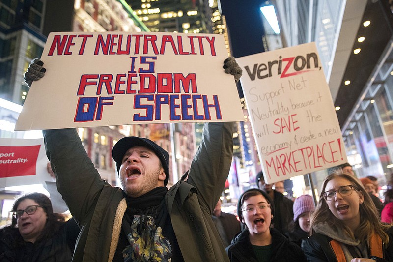 In this Thursday, Dec. 7, 2017, file photo, demonstrators rally in support of net neutrality outside a Verizon store in New York. The Federal Communications Commission voted Thursday, Dec. 14 to undo Obama-era "net neutrality" rules that guaranteed equal access to the internet. The industry promises that the internet experience isn't going to change, but the issue has struck a nerve with the public.