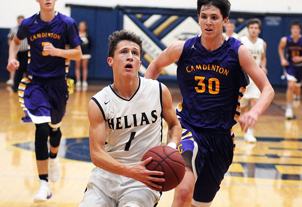 Helias guard Nick Brandt drives the lane past Camdenton's Kelton Virtue (30) after making a steal in a game earlier this season at Rackers Fieldhouse.