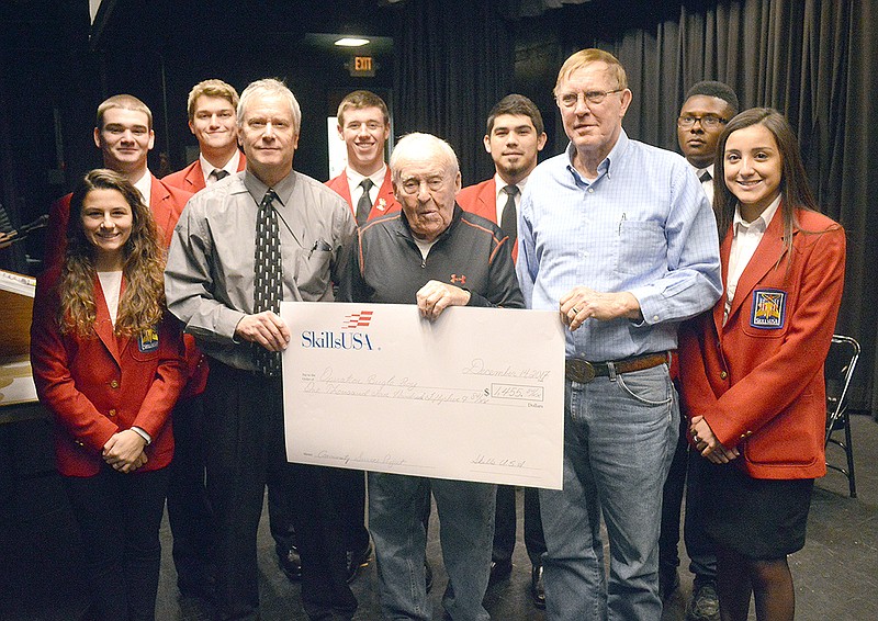 Nichols Career Center students presented the results of their community service for Operation Bugle Boy in the form of a check for $1,455.84 on Thursday at Jefferson City High School's Little Theatre. Chris Jarboe, left, president of Operation Bugle Boy, Coach Pete Adkins and Don Hentges were on hand to receive the funds from the SkillsUSA students.