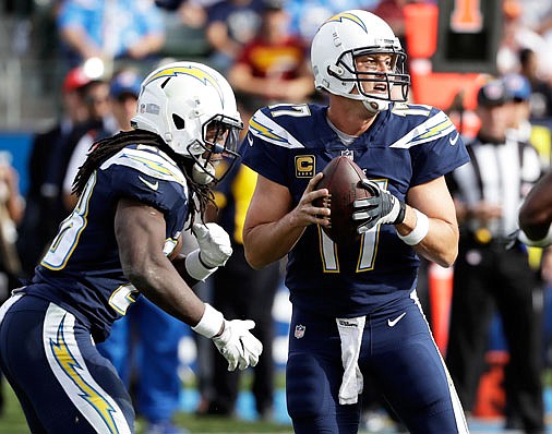 Chargers quarterback Philip Rivers drops back to pass, flanked by running back Melvin Gordon during last Sunday's game against the Redskins in Carson, Calif.