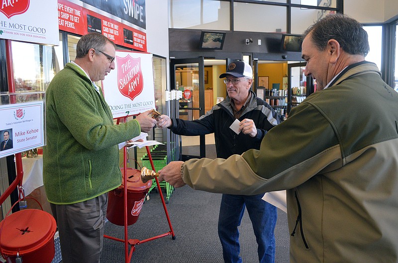 Nip Neidert hands a contribution to Bernie Fechtel, president of Fechtel Beverage and chair of The Salvation Army's 2017 Red Kettle Campaign, as Sen. Mike Kehoe rings away Dec. 16, 2017 during the morning's Red Kettle Ring Off at Hy-Vee. Fechtel and longtime friend Kehoe went head to head in their friendly challenge with Fechtel boasting the fact that he had the bigger kettle. 