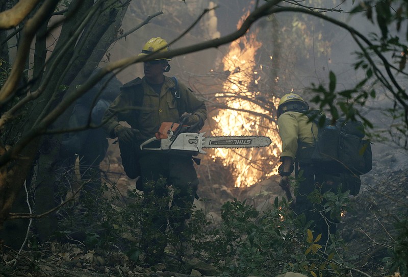 Firefighters from Kern County, Calif., work to put out hot spots during a wildfire Saturday, Dec. 16, 2017, in Montecito, Calif. (AP Photo/Chris Carlson)